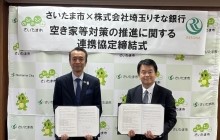 さいたま市清水勇人市長と株式会社埼玉りそな銀行福岡聡代表取締役社長（現会長）が協定式で協定締結を記念して協定書を掲げる様子
