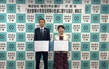 行田市行田邦子市長と株式会社埼玉りそな銀行福岡聡代表取締役社長（現会長）が協定式で協定締結を記念して協定書を掲げる様子
