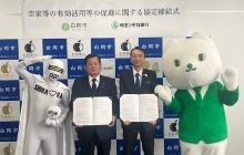 白岡市藤井栄一郎市長と株式会社埼玉りそな銀行福岡聡代表取締役社長（現会長）が両者のマスコットキャラクターと、協定式で協定締結を記念して協定書を掲げる様子