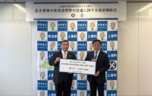 上里町山下博一町長と株式会社埼玉りそな銀行石井良輔執行役員埼玉県央・北地域営業本部長が協定式で協定締結を記念してパネルを掲げる様子