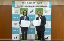 朝霞市松下昌代市長と株式会社埼玉りそな銀行吉岡浩司執行役員埼玉西地域営業本部長が協定式で協定締結を記念して協定書を掲げる様子