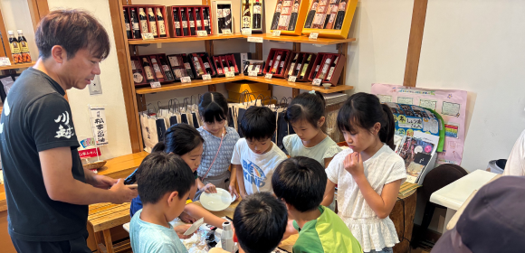 お醤油をおせんべいに塗って焼く試食体験の様子の画像