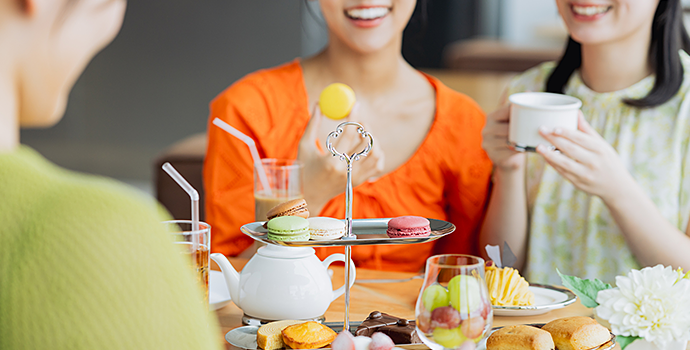 テーブルを囲む3人の前に、マカロンやケーキ、焼き菓子、飲み物が並んでいる。