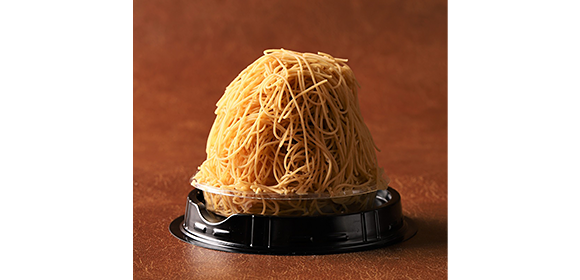 細い黄色のクリームが山状に盛られたスイーツが、黒いプラスチック容器に入っている。